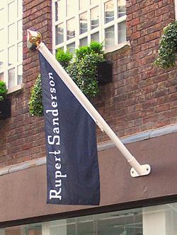 printed angled flag on a flagpole outside a shop