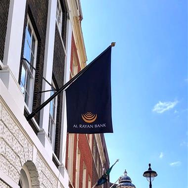 black angled flag on a flagpole on a bank wall
