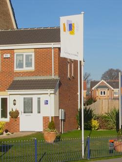 builders flagpoles outside a new showhouse 