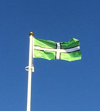 Devon county flag flying from a flagpole on a sunny day 