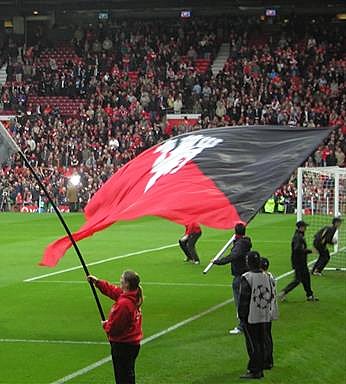 hand waving flagpoles at a football match